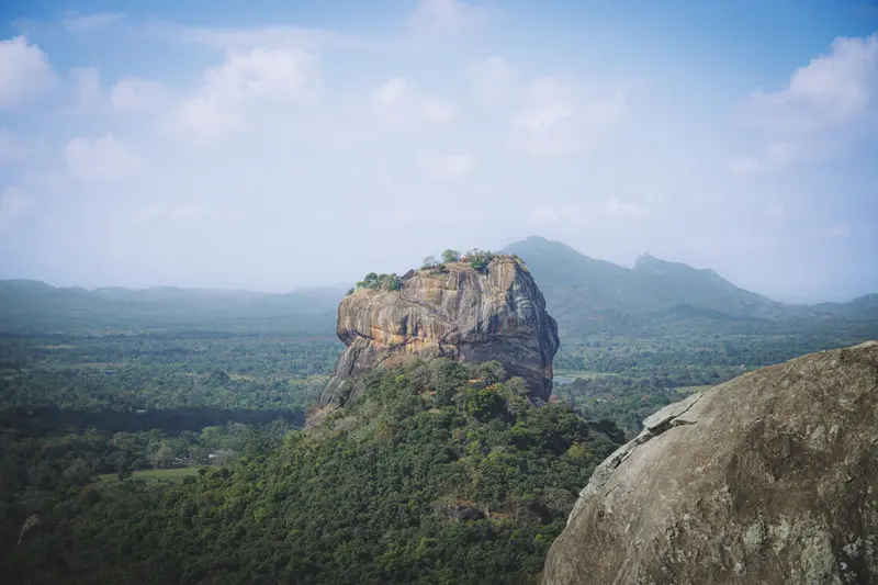 Sigiriya rock fortress rising above forest in Sri Lanka